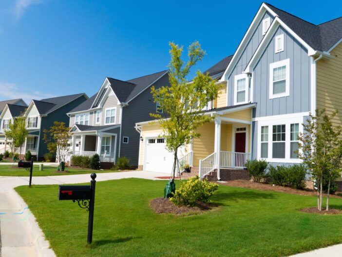 A residential/ suburban neighborhood with large houses and manicured lawns.